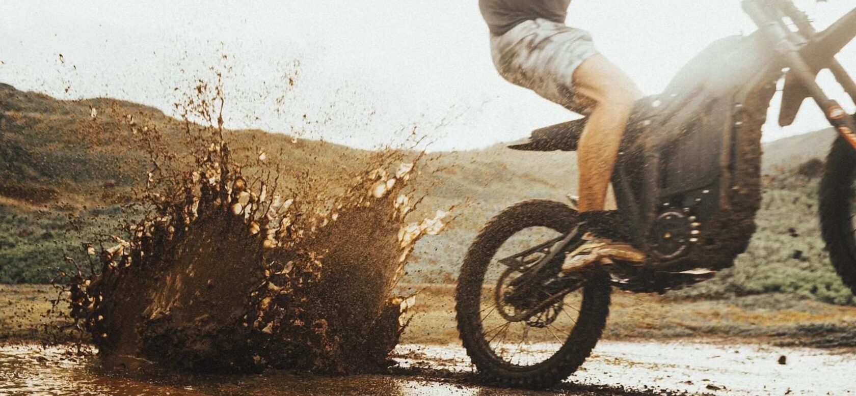Electric dirt bike riding through mud